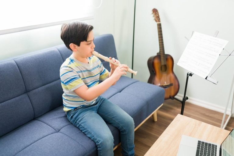 developing my musical skills caucasian elementary boy playing his favorite song flute while sitting living room his online lessons 662251 1602 768x512